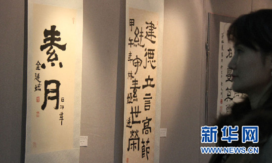 中國(guó)僑網(wǎng)兩名參觀者在觀看歷屆首爾中國(guó)文化中心優(yōu)秀學(xué)員書(shū)法作品,。
