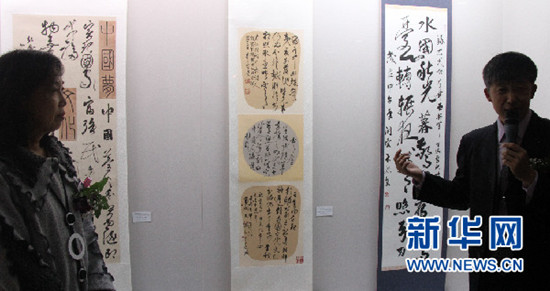 中國(guó)僑網(wǎng)韓國(guó)書(shū)法藝術(shù)院院長(zhǎng),、首爾中國(guó)文化中心書(shū)法班老師葉欣(右)在向參觀者介紹歷屆首爾文化中心優(yōu)秀學(xué)員書(shū)法作品,。