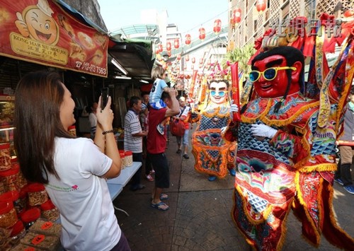 中國(guó)僑網(wǎng)造型前衛(wèi)的三太子擺好姿勢(shì)讓美女拍照,,并一改蹦蹦跳跳調(diào)皮的模樣,,逗得路人笑開了懷。(馬來(lái)西亞《光明日?qǐng)?bào)》)