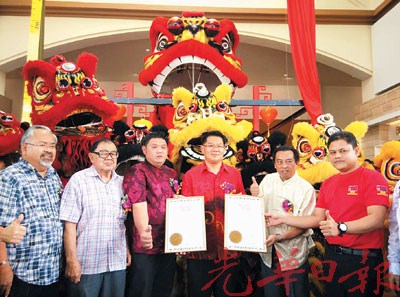 中國(guó)僑網(wǎng)林萬(wàn)鋒(右3)展示全馬最大獅王的大馬紀(jì)錄大全證書(shū),。(馬來(lái)西亞《光華日?qǐng)?bào)》)
