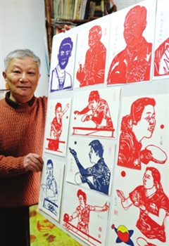 中國僑網(wǎng)剪紙藝人章維偉正在展示他的作品:“為乒乓世界冠軍剪影”。作品上每一個人物的頭發(fā),、服飾圖案甚至皺紋均清晰可見,,表情、打球動作也栩栩如生,。(杭興微 攝)