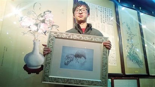 中國僑網(wǎng)張雪展示他創(chuàng)作的私人訂制婚慶素描刺繡,。(趙征南 攝)