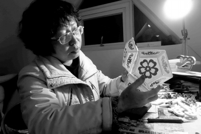 中國(guó)僑網(wǎng)非遺傳承人蔡聰慧正在精心制作針刺無(wú)骨花燈。(潘珊菊 攝)