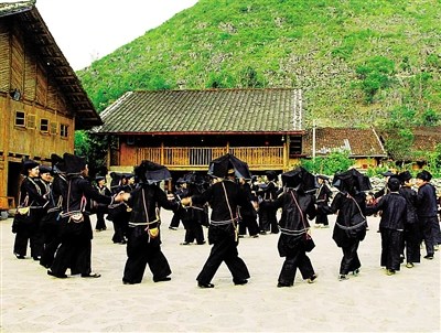 中國(guó)僑網(wǎng)黑衣壯們圍在一起跳舞。