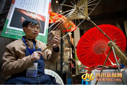 中國僑網(wǎng)第六代傳人畢六福在制作油紙傘,。