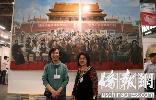 中國(guó)僑網(wǎng)溫州籍華裔藝術(shù)家何可人夫婦在自己的巨幅油畫前。(美國(guó)《僑報(bào)》/管黎明 攝)