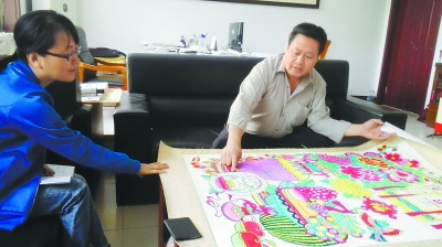 中國(guó)僑網(wǎng)康英勤向記者展示其年畫(huà)作品。(曹斌 攝)