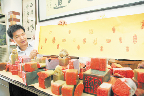 中國僑網(wǎng)在工作室里,林旭平正向記者展示自己的系列篆刻作品《離騷》,。(陳飛 攝)