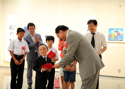 向獲獎(jiǎng)青少年代表頒發(fā)證書(shū),,中間的小男孩才5歲,。(日本《中文導(dǎo)報(bào)》)