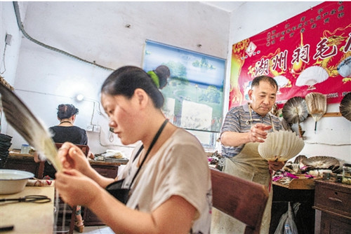 在湖州羽毛扇廠簡陋的車間里,,工人在制作羽毛扇