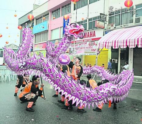 游行沿途中有舞龍表演助興。(馬來西亞《星洲日報》)