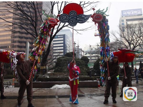 1月26日,在韓國首爾鬧市區(qū),,來自湖北十堰的民間藝人表演鳳凰燈舞