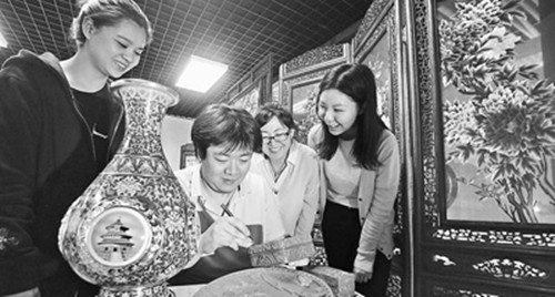 5月10日,觀眾在觀看工匠技師雕刻雕漆禮盒(賀勇