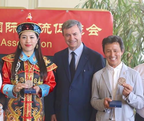 勒考克向孔麗娜(左),、楊玉龍(右)頒發(fā)了紀念章,,以表彰他們對法中文化交流做出的貢獻,。(法國《歐洲時報》/孔帆