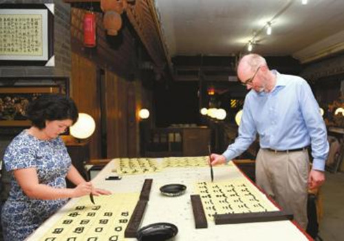9日,美國駐成都總領(lǐng)事谷立言(右)和領(lǐng)事彭莉莎(左)在學(xué)習(xí)書法,。(劉陳平