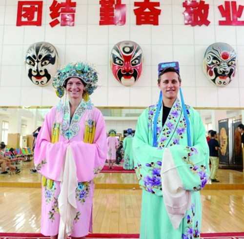 德國(guó)大學(xué)生斯特凡·格拉丁格爾(右)與同學(xué)在山東省京劇院試穿京劇演出服裝。(蘇銳