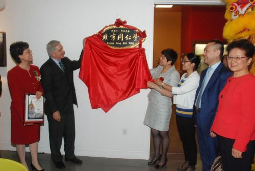北京同仁堂集團執(zhí)行總裁丁永玲(右四)和加州整合學院校長約瑟夫·索比昂多(左二)等嘉賓,為中心開幕揭牌,。(美國《僑報》/吳卓明
