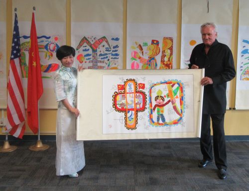 范家飛將兒童所繪制的畫字送給好萊塢導(dǎo)演克里比,。(美國《僑報》/翁羽