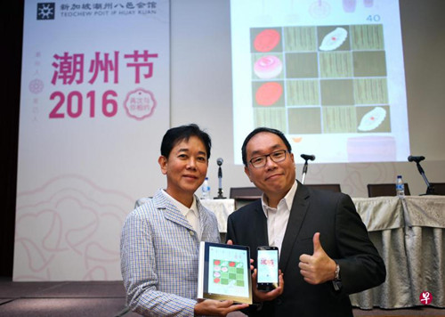 潮州八邑會館會長郭明忠(左)和潮州節(jié)籌委會主席林雍杰所展示的手機(jī)游戲“Heng