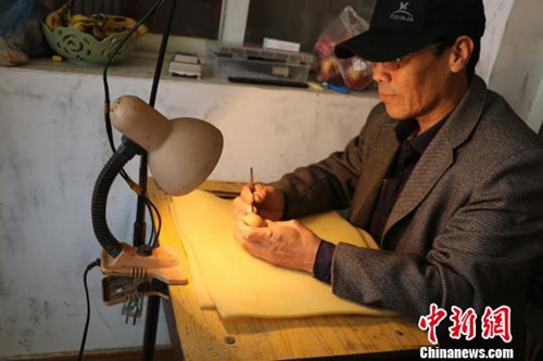 中國(guó)僑網(wǎng)李世華正在進(jìn)行雕刻。(張春娥 攝)