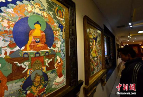 中國僑網(wǎng)觀眾正在欣賞展覽中的唐卡作品。(李林 攝)