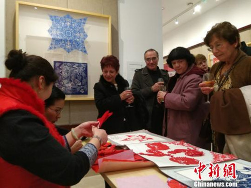 中國僑網(wǎng)“花的絮語-中國剪紙藝術精品展”在馬耳他首都瓦萊塔展出,。當?shù)孛癖姾闷娴赜^看藝人創(chuàng)作剪紙作品。(王大衛(wèi) 攝)