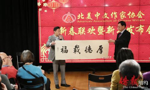 中國(guó)僑網(wǎng)《僑報(bào)》總裁游江捐贈(zèng)自己的書法作品作為聯(lián)歡活動(dòng)的獎(jiǎng)品之一。(美國(guó)《僑報(bào)》/管黎明 攝)