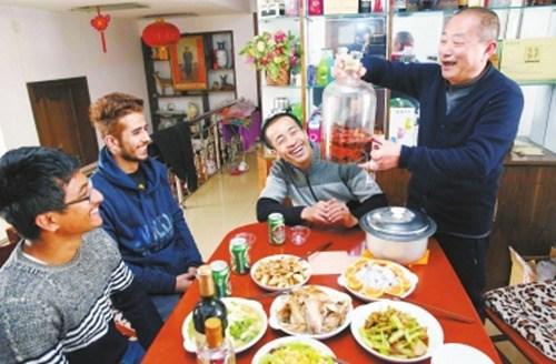 中國(guó)僑網(wǎng)熱情的漯河人拿出自制的酒,款待外國(guó)友人,。(劉廣超 攝)