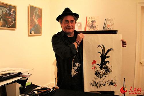 中國(guó)僑網(wǎng)法國(guó)畫(huà)家皮爾康展示即興創(chuàng)作的雞年主題水墨畫(huà)。(李永群 攝)