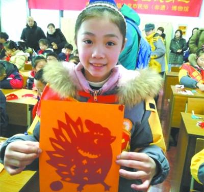 中國僑網(wǎng)孩子開心地展示自己的剪紙作品