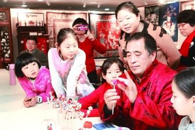 中國僑網(wǎng)非遺傳承人高繼澤教孩子們捏面塑,。