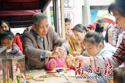 中國(guó)僑網(wǎng)茶山公仔傳承人林暖欽正在教孩子上色。