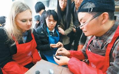 中國僑網圖為來自俄羅斯的留學生在周寶康(右)指導下學習制作泥叫叫,。 楊 雨 攝(人民視覺)