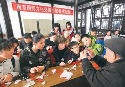 中國僑網(wǎng)圖為民間藝人講解剪紙技巧,。 李文寶攝 (新華社發(fā))