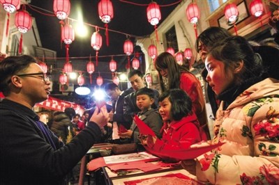 中國僑網(wǎng)在市區(qū)朔門街,,朱銘教孩子們剪窗花。