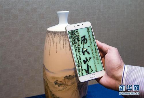 中國僑網(wǎng)5月14日,,在瑞士日內(nèi)瓦舉行的陶瓷微書作品展上,,一名參觀者用手機拍攝一件陶瓷微書展品,。(新華社記者 徐金泉 攝)