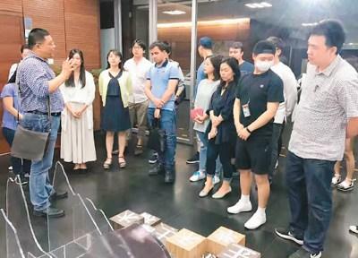 中國僑網(wǎng)孟德宏(左一)在展覽現(xiàn)場為北京外國語大學(xué)來自菲律賓等國的留學(xué)生上了一堂中國語言文化課,。