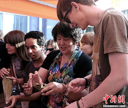 中國僑網(wǎng)圖為正在包粽子的學(xué)生,。(中新社發(fā) 王舒 攝)