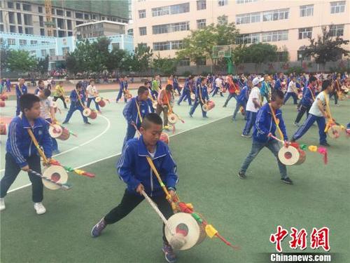 中國僑網(wǎng)圖為皋蘭石洞小學(xué)的3年級學(xué)生放學(xué)后,跑去操場上練習(xí)國家非物質(zhì)文化遺產(chǎn)太平鼓,?!∈缝o靜 攝