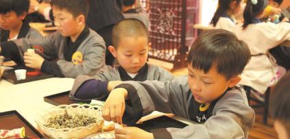 中國僑網(wǎng)聚隆光明中醫(yī)藥傳承教育中心的“小中醫(yī)”正在稱量中藥,。
