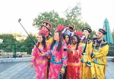 中國僑網(wǎng)身穿中國古代皇宮服飾的外國友人在北京景山公園自拍留念,。 本報(bào)記者 高炳 攝