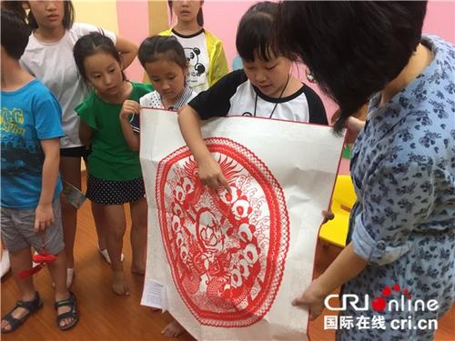 中國僑網熊貓小記者向新加坡北京語文學校老師贈送中國傳統剪紙