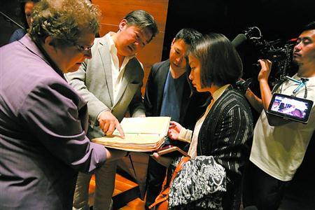 中國僑網(wǎng)克里斯緹娜(左一)介紹紀(jì)念冊內(nèi)容,。 蔡磊磊 攝