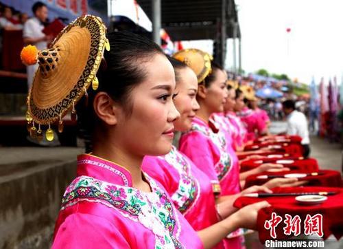 中國僑網(wǎng)資料圖:頭戴花竹帽的毛南族姑娘?!钪拘邸z