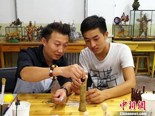 中國僑網(wǎng)胡旭春正在教授學(xué)生,?!罱苡ⅰz