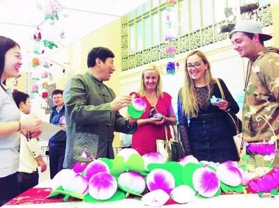 中國(guó)僑網(wǎng)顧業(yè)亮向外國(guó)觀眾介紹秦淮花燈的制作方法,。本報(bào)記者 朱凱攝