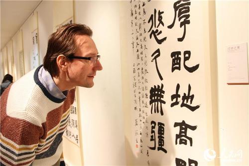 中國僑網(wǎng)俄羅斯民眾認真欣賞中國書法家的漢字作品,。(人民網(wǎng)記者 華迪 攝)