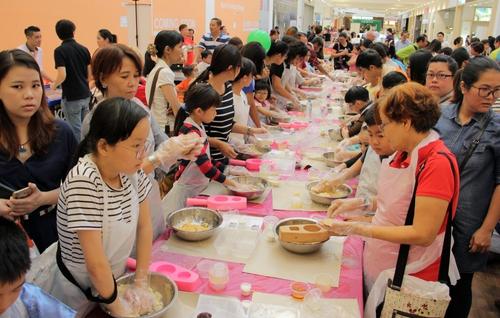 中國僑網數(shù)百人集體放下手機,搓起面團動手做月餅,,重溫中秋團圓之意。(馬來西亞《星洲日報》)