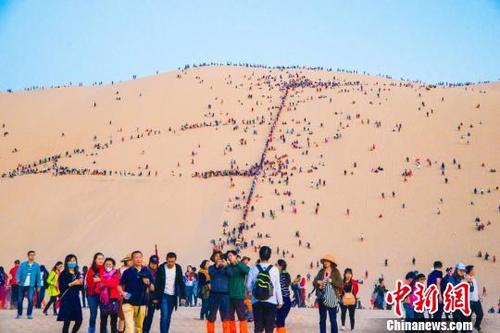 中國僑網(wǎng)10月3日,敦煌鳴沙山上人流如織?!⊥醣筱y 攝