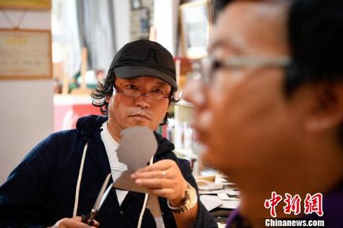 中國僑網(wǎng)圖為汪元在剪紙創(chuàng)作,?!⑷疥枴z